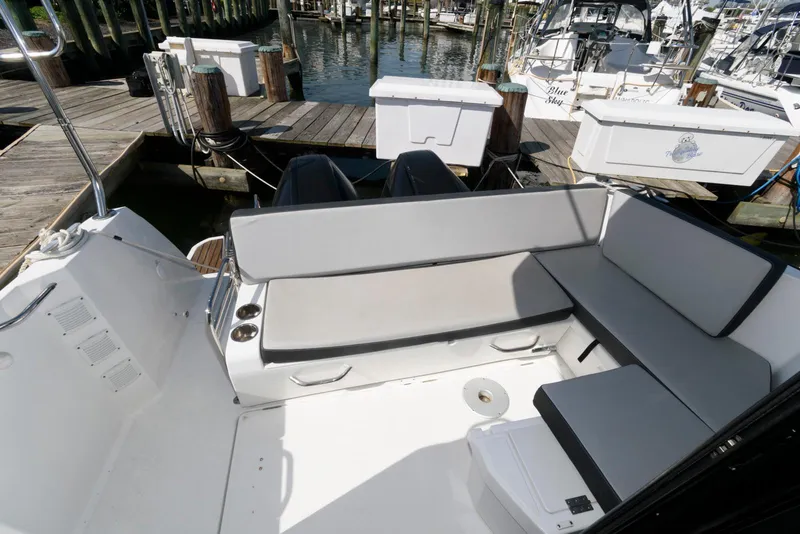 Slide: The Image of 2019 Jeanneau NC 895 boat interior with cushioned seating and dock view. - 11