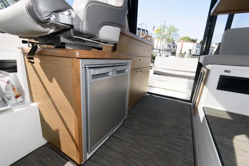 Slide: The Image of 2019 Jeanneau NC 895 interior with compact kitchen and seating area. - 16