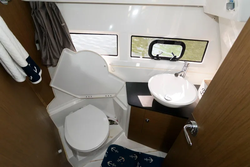 Slide: The Image of 2019 Jeanneau NC 895 boat bathroom with toilet, sink, and window. - 18