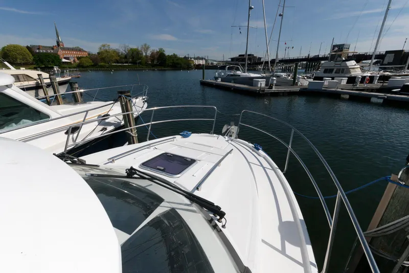 Slide: The Image of 2019 Jeanneau NC 895 docked in a marina, surrounded by other boats. - 19