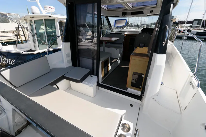 Slide: The Image of 2019 Jeanneau NC 895 boat interior with seating and helm, docked at marina. - 5