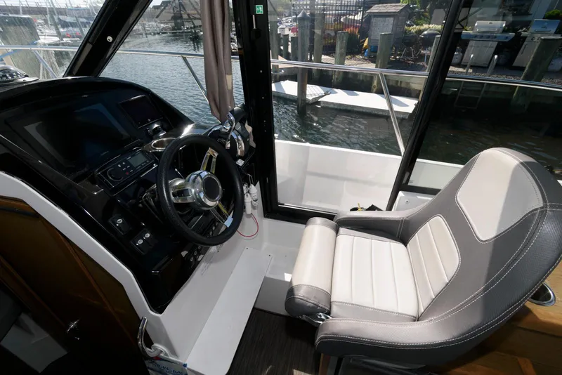Slide: The Image of 2019 Jeanneau NC 895 helm with steering wheel and captain's chair, dockside view. - 7