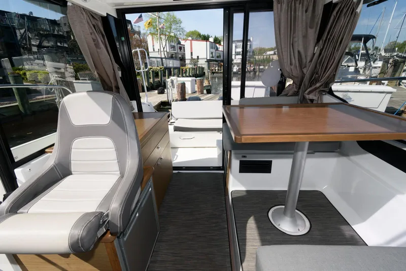 Slide: The Image of Interior of 2019 Jeanneau NC 895 boat with seating and table, docked at marina. - 9
