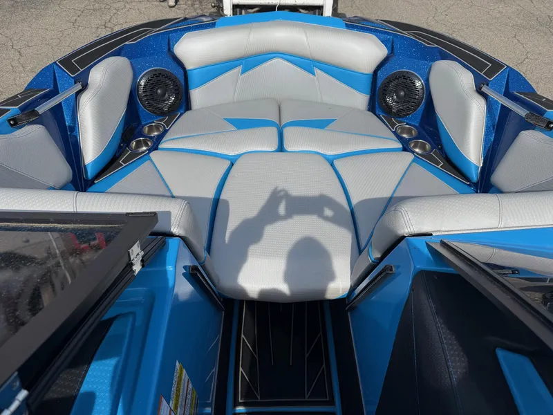 Slide: The Image of 2022 Centurion Fi23 boat interior with blue and gray seating, speakers, and cup holders. - 2