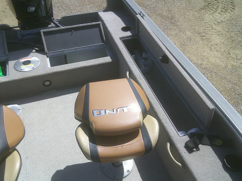 Slide: The Image of 2006 Lund 1600 Explorer SS boat interior with brown seating and storage compartments. - 14