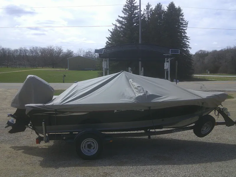 Slide: The Image of 2006 Lund 1600 Explorer SS boat covered on trailer, parked outdoors. - 17