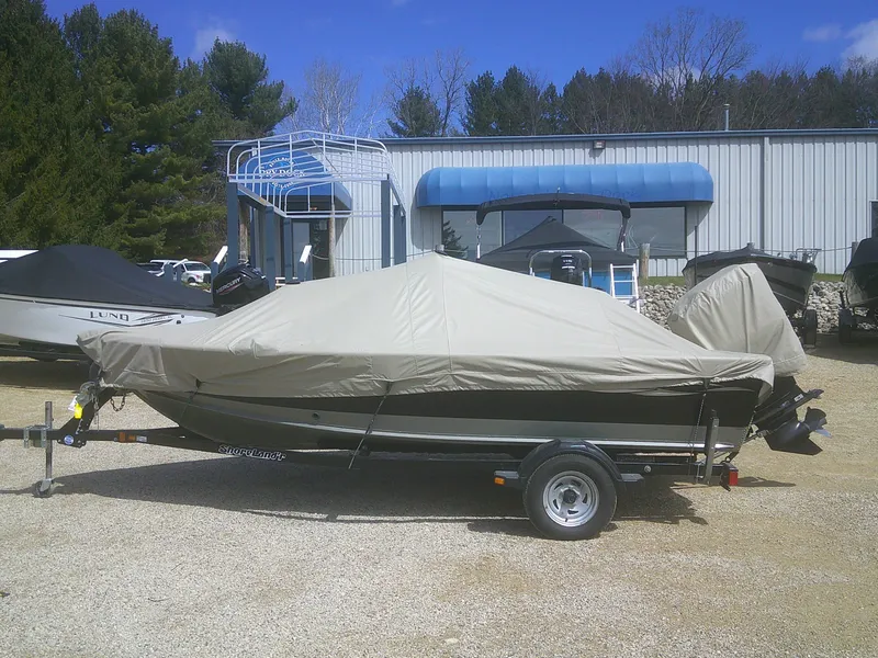 Slide: The Image of Covered 2006 Lund 1600 Explorer SS boat on trailer, parked outdoors near a building. - 18