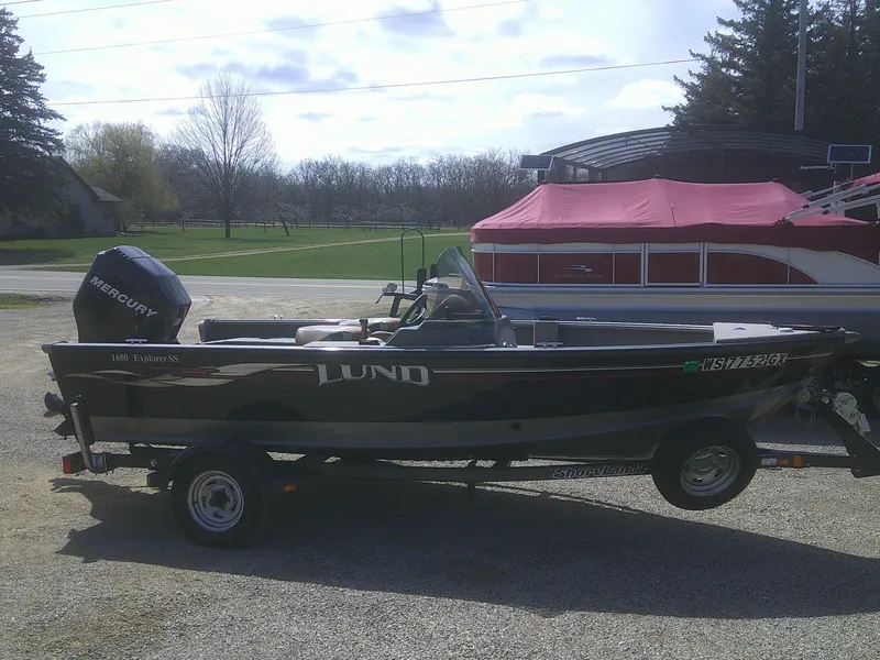 Slide: The Image of 2006 Lund 1600 Explorer SS boat on trailer with Mercury outboard motor, parked outdoors. - 3