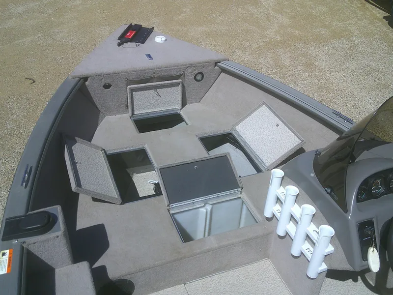 Slide: The Image of 2006 Lund 1600 Explorer SS boat interior with open storage compartments and rod holders. - 8