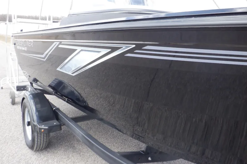 Slide: The Image of 2023 Crestliner 1650 Fish Hawk SE WT boat on trailer, sleek black exterior design. - 40