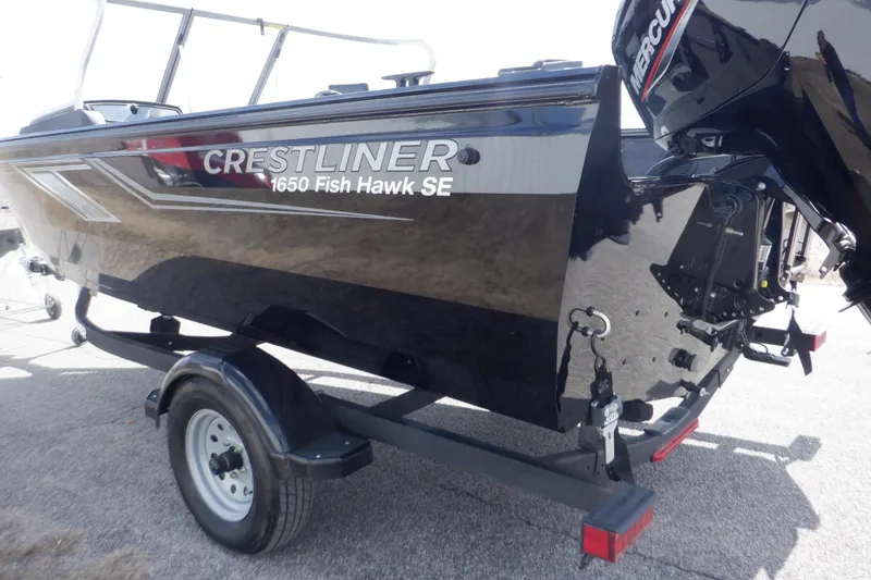 Slide: The Image of 2023 Crestliner 1650 Fish Hawk SE WT boat on trailer, featuring a sleek black design. - 6
