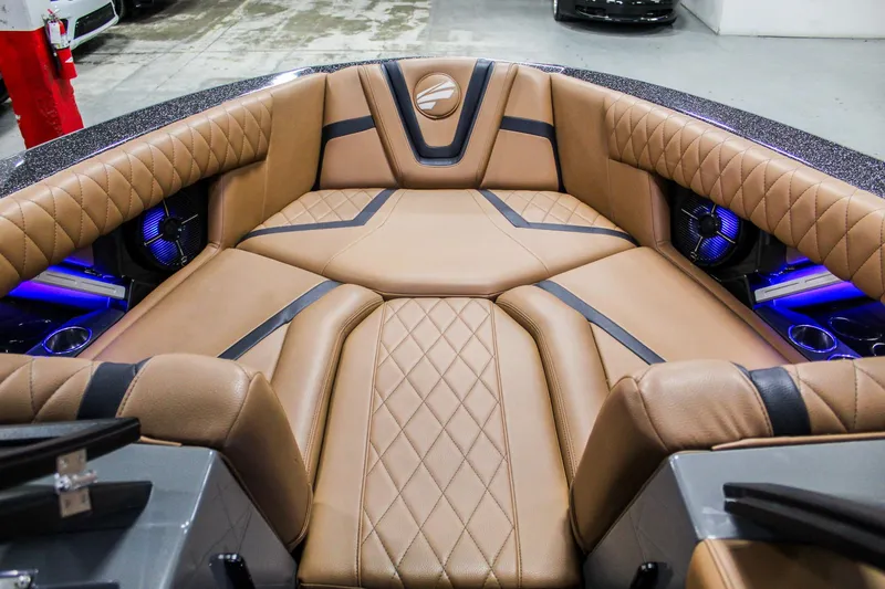 Slide: The Image of Luxurious interior of 2021 Tigé 25ZX boat with tan leather seating and blue LED lights. - 11