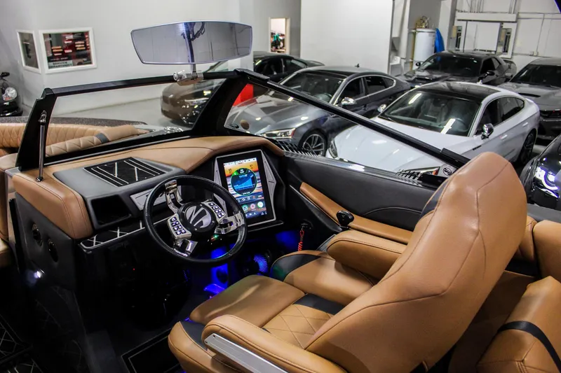 Slide: The Image of 2021 Tigé 25ZX boat interior with tan leather seats and modern dashboard. - 12