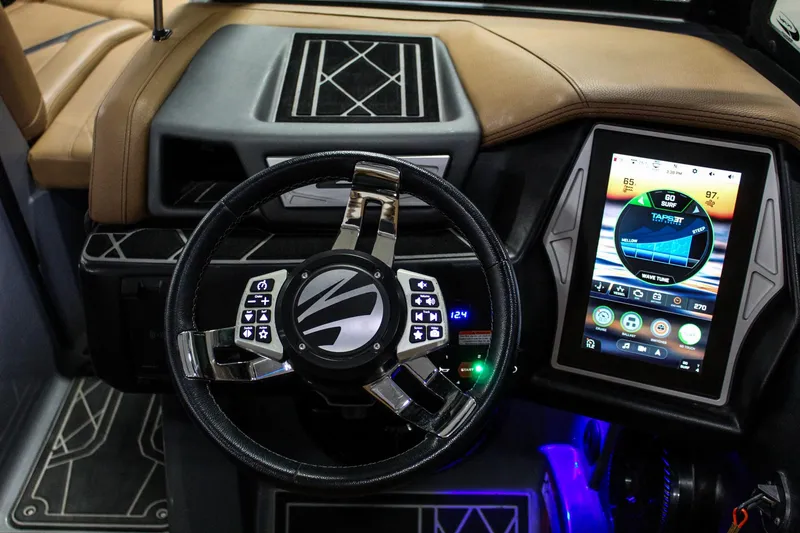 Slide: The Image of 2021 Tigé 25ZX boat dashboard with touchscreen controls and modern steering wheel. - 13