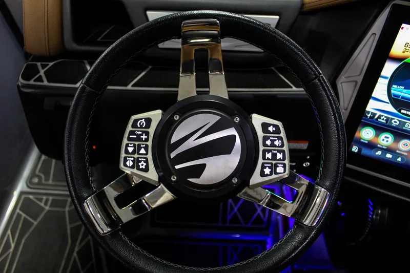 Slide: The Image of Steering wheel of 2021 Tigé 25ZX boat with control buttons and modern design. - 14