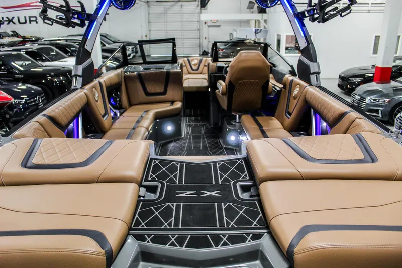 Slide: The Image of 2021 Tigé 25ZX boat interior with luxurious brown seating and modern design. - 18