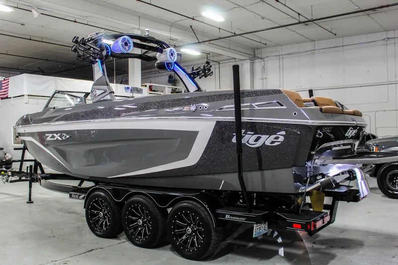 Slide: The Image of 2021 Tigé 25ZX boat in a showroom, featuring sleek design and advanced audio system. - 3