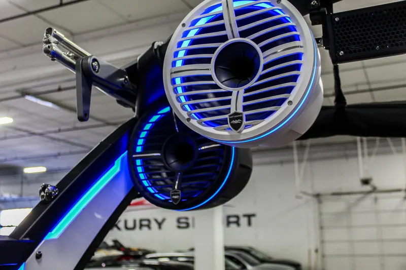 Slide: The Image of 2021 Tigé 25ZX boat speakers with blue LED lights in a showroom. - 32