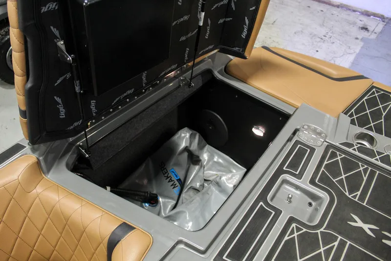 Slide: The Image of 2021 Tigé 25ZX boat storage compartment with open lid, showcasing interior design and materials. - 36