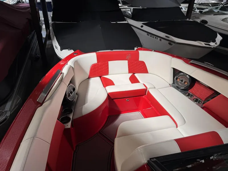 Slide: The Image of 2020 MasterCraft X26 boat interior with red and white seating, docked in a marina. - 10