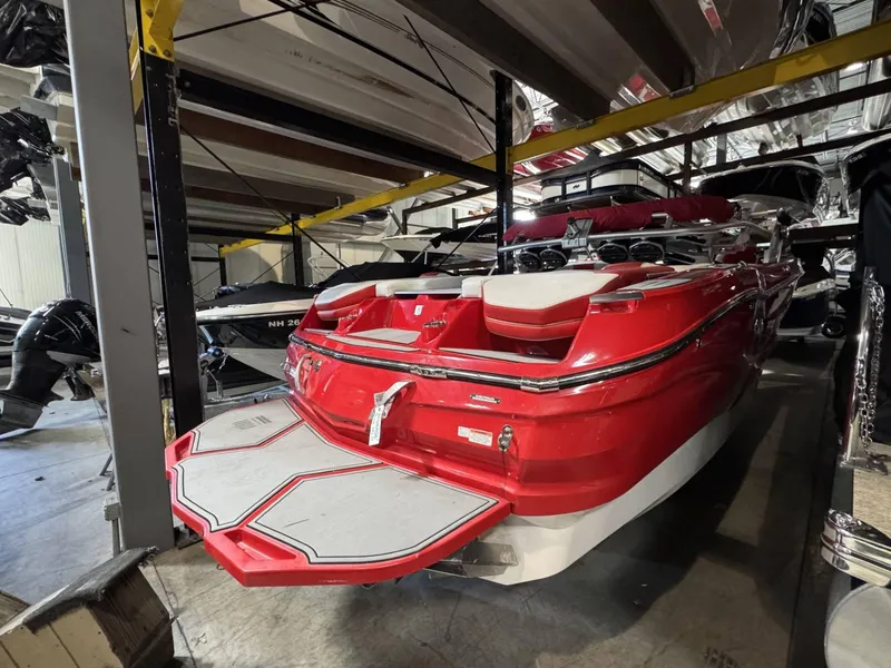 Slide: The Image of 2020 MasterCraft X26 boat in storage, vibrant red color, rear view. - 3
