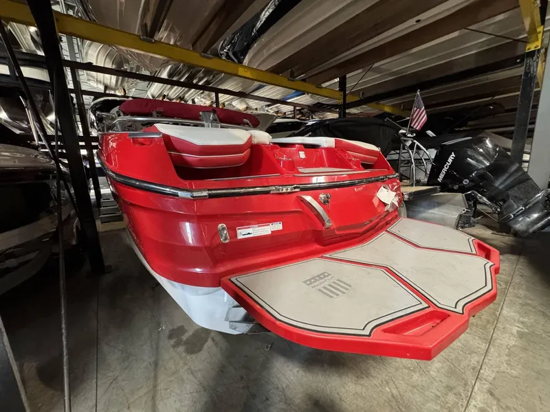 Slide: The Image of 2020 MasterCraft X26 boat in storage, red exterior, swim platform visible. - 4