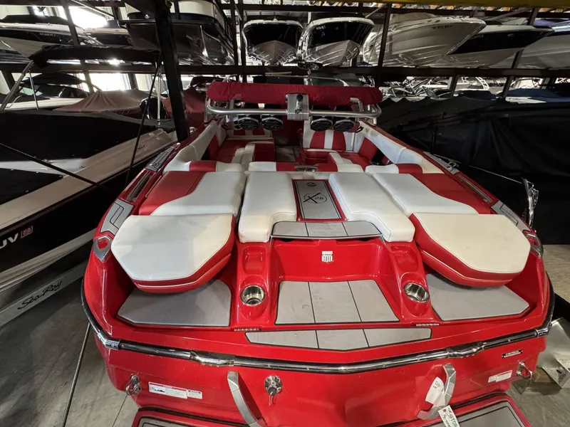Slide: The Image of 2020 MasterCraft X26 boat with red and white interior, docked in a storage facility. - 5