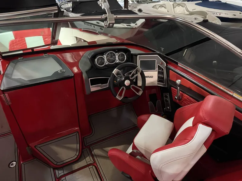 Slide: The Image of 2020 MasterCraft X26 boat interior with red and white seating, modern dashboard, and steering wheel. - 9
