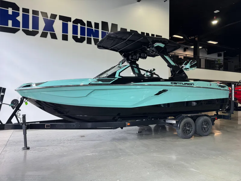 Slide: The Image of 2024 Centurion RI 245 boat in showroom, turquoise and black design, on a trailer. - 3