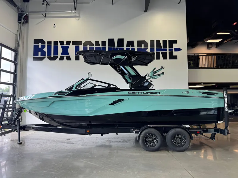 Slide: The Image of 2024 Centurion RI 245 boat in showroom, turquoise and black design, on trailer. - 4
