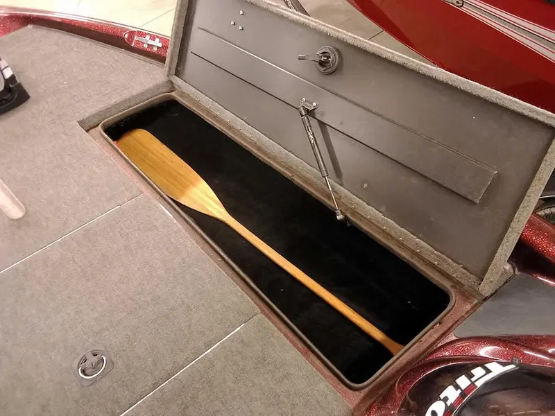 Slide: The Image of 2001 Triton TR186 sc boat storage compartment with wooden paddle. - 14
