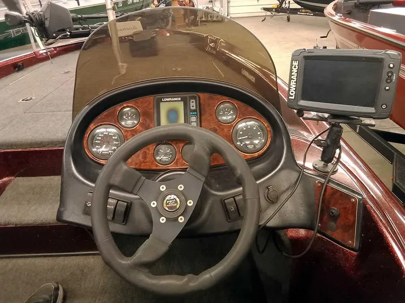 Slide: The Image of 2001 Triton TR186 SC boat dashboard with steering wheel and Lowrance fishfinder. - 24