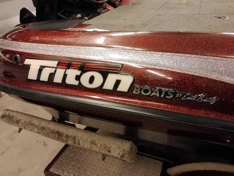 Slide: The Image of 2001 Triton TR186 SC boat with red metallic finish and logo detail. - 31