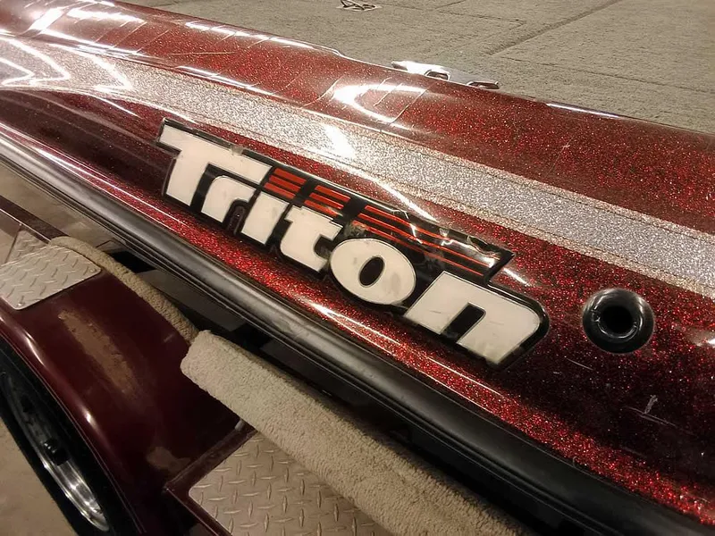 Slide: The Image of 2001 Triton TR186 SC boat with metallic red finish and logo detail. - 9