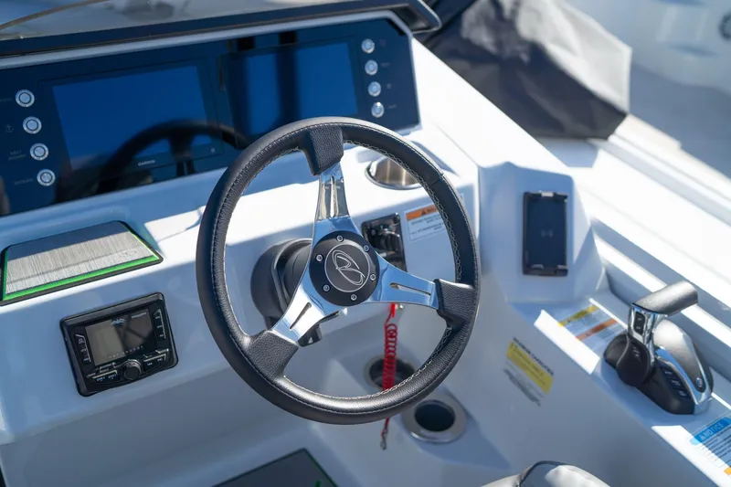 Slide: The Image of 2024 Veranda Vertex 25RL boat dashboard with steering wheel and control panel. - 8