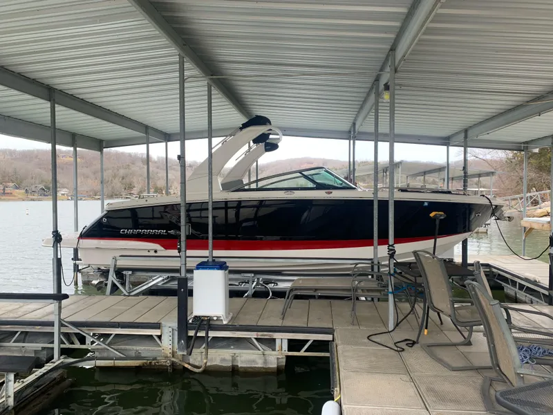 Slide: The Image of 2019 Chaparral 277 SSX boat docked under a covered marina. - 1