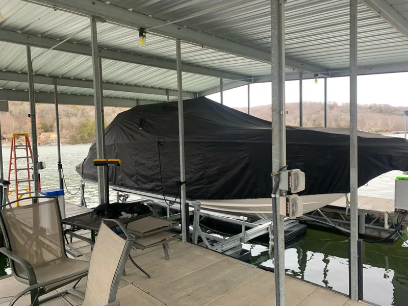Slide: The Image of Covered 2019 Chaparral 277 SSX boat docked under a metal canopy by the lake. - 4