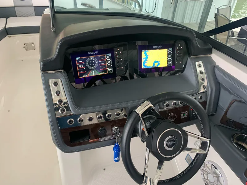 Slide: The Image of 2019 Chaparral 277 SSX dashboard with dual Simrad displays and modern steering wheel. - 6