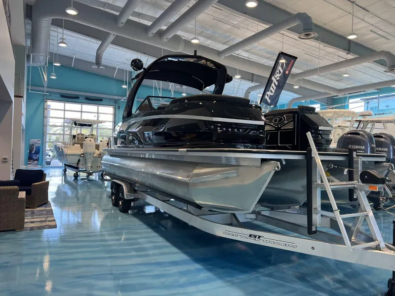 Slide: The Image of 2024 Veranda V One 25 pontoon boat displayed in a showroom with a sleek design. - 0