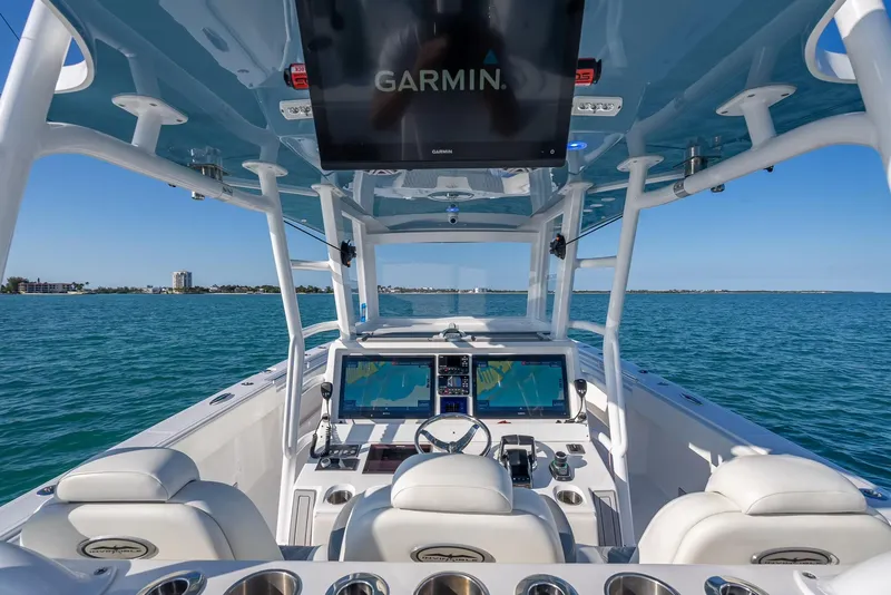 Slide: The Image of 2023 Invincible 37 Catamaran cockpit with Garmin navigation, ocean view, and modern controls. - 32