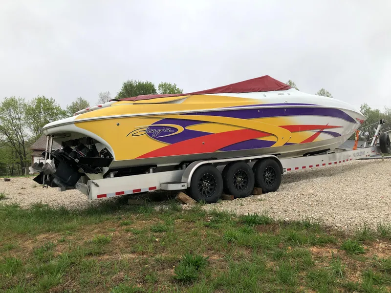 Slide: The Image of 2002 Baja .38 Special boat on trailer, vibrant yellow and purple design, parked outdoors. - 2