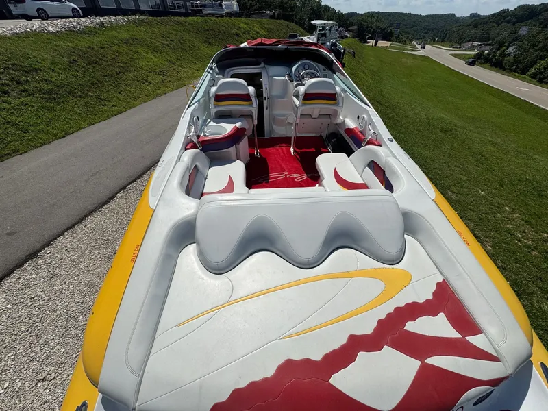 Slide: The Image of 2002 Baja .38 Special boat with colorful interior, parked on grass near a road. - 4