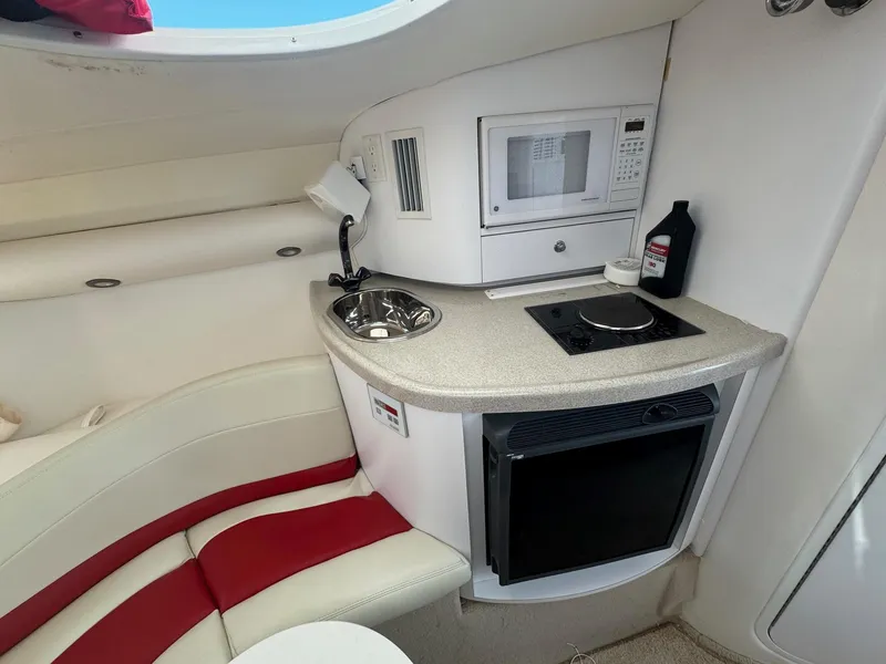 Slide: The Image of Compact boat kitchenette with microwave, sink, and stove in a 2002 Baja .38 Special. - 9