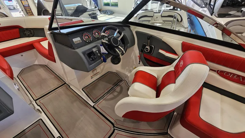 Slide: The Image of 2020 Cobalt CS22 boat interior with red and white seating, modern dashboard, and steering wheel. - 13
