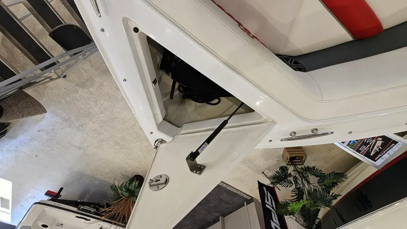 Slide: The Image of 2020 Cobalt CS22 boat interior storage compartment with open hatch, white and red seating. - 19