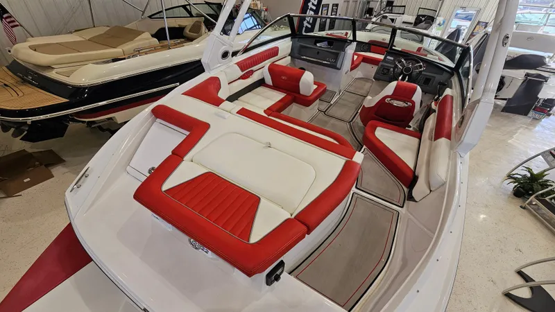 Slide: The Image of 2020 Cobalt CS22 boat with red and white interior, showcased in a showroom. - 7