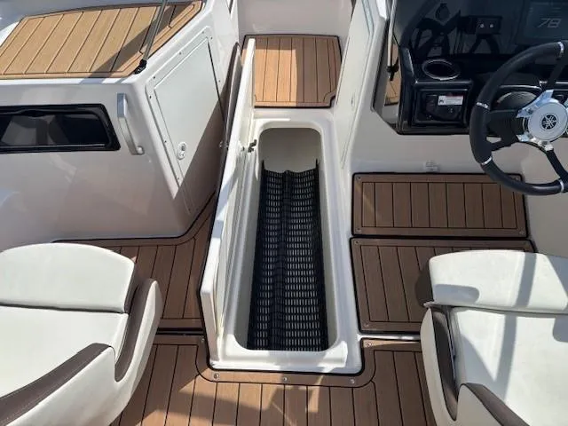 Slide: The Image of 2022 Yamaha Boats 195S interior with teak flooring and storage compartment. - 12