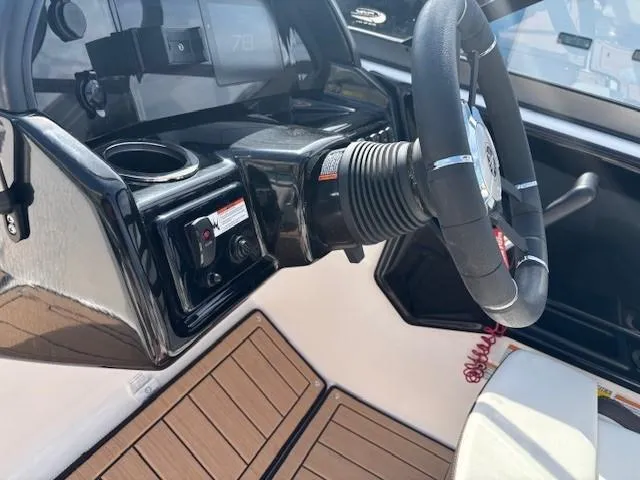 Slide: The Image of 2022 Yamaha Boats 195S steering wheel and dashboard, featuring modern controls and wood-style flooring. - 17