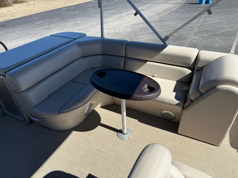 Slide: The Image of 2019 South Bay 222CR pontoon boat interior with beige seating and a round table. - 12