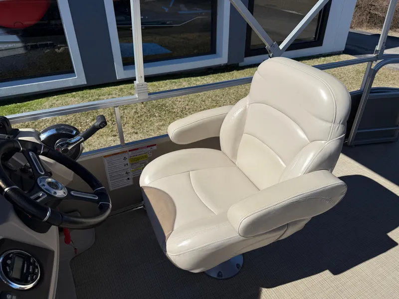 Slide: The Image of Captain's chair on 2019 South Bay 222CR pontoon boat, featuring beige upholstery and steering wheel. - 16